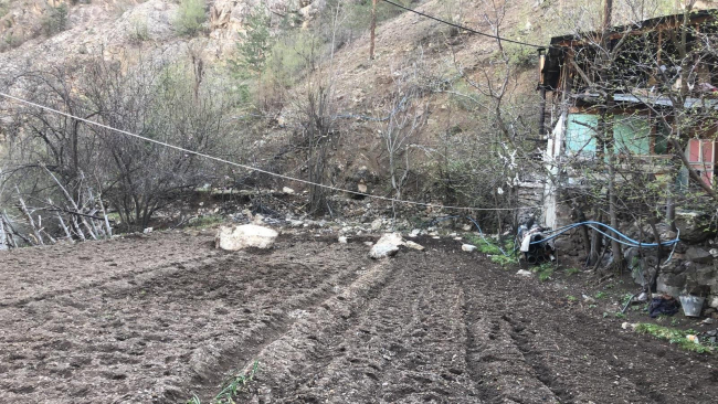 Yamaçtan kopan dev kayalar evin bahçesine düştü